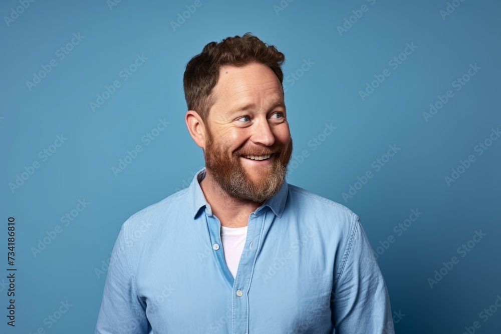 Portrait of a cheerful bearded man in a blue shirt on a blue background Portrait of a cheerful bearded man in a blue shirt on a blue background