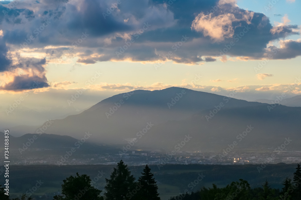 Scenic sunset view of mountain range Bleiberg Erzberg seen from Altfinkenstein, Baumgartnerhoehe, Carinthia, Austria. Tranquility on hiking trail. Overlooking Villach area surrounded by Austrian Alps