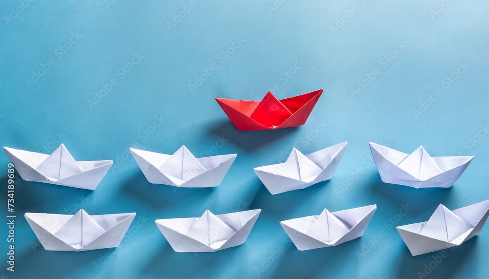 group of white paper ship in one direction and one red paper ship pointing in different way on blue background business for innovative solution concept