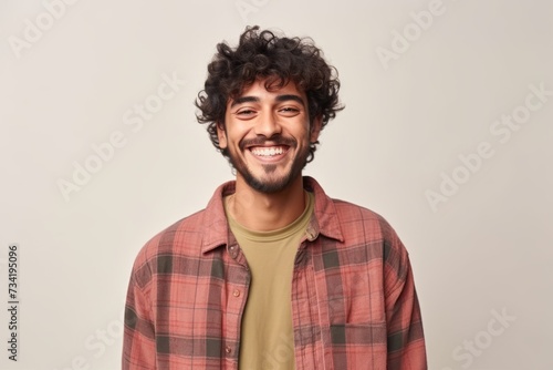 Cheerful young man in checkered shirt smiling and looking at camera