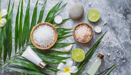 spa treatment concept natural organic spa cosmetics products sea salt and tropic palm leaves on gray marble table from above spa background with a space for a text flat lay top view