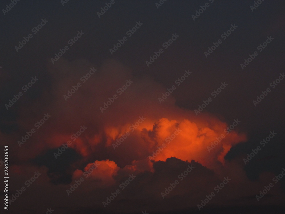 Naklejka premium Celestial show. A unique and magical moment in which the sun bids farewell with a burst of color that transforms the sky and the clouds into a work of art.