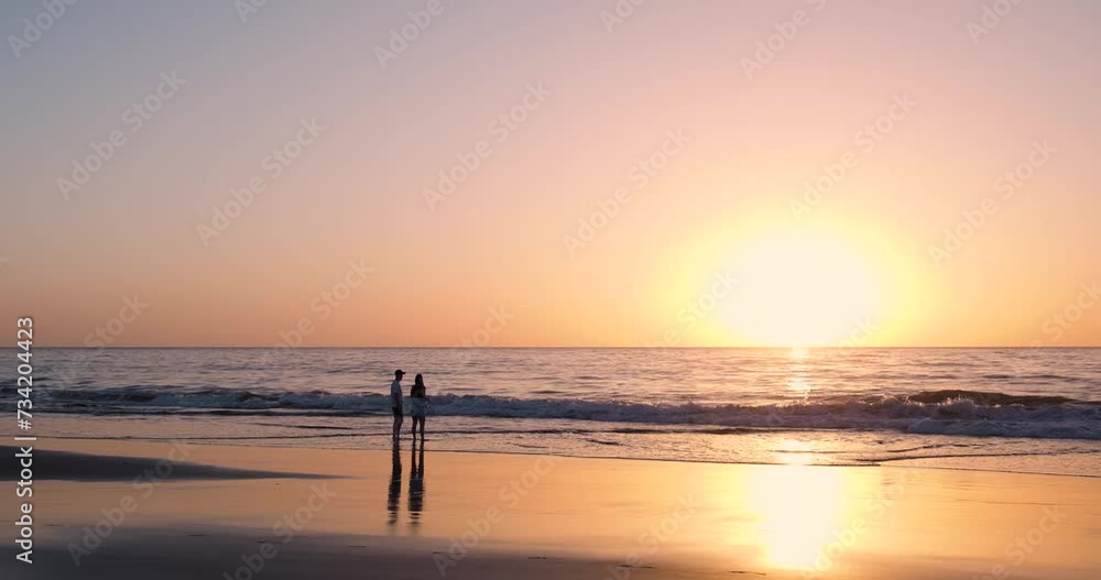 Couple watching sunrise at the beach Couple watching sunrise at the beach