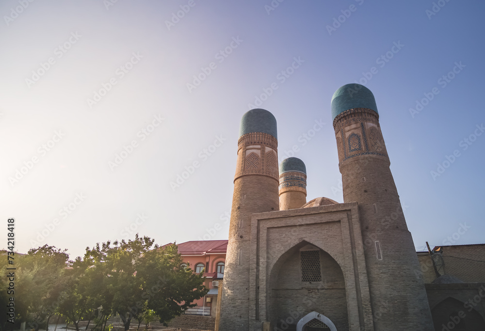 Fototapeta premium Exterior of Chor Minor Madrasah in the ancient city of Bukhara in Uzbekistan, oriental architecture at sunset in the evening