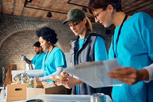 Foto Group of volunteers sorting food in donation boxes at humanitarian aid center
