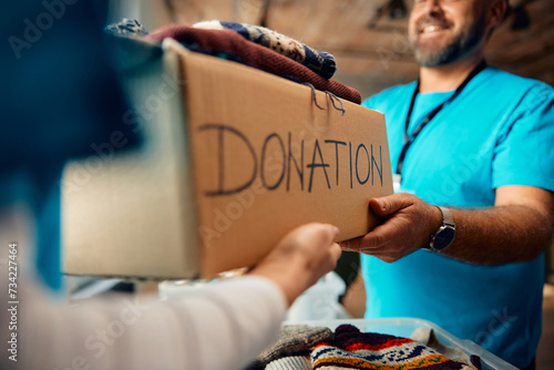 Close up of volunteers sorting donation boxes with clothes at community center. photo