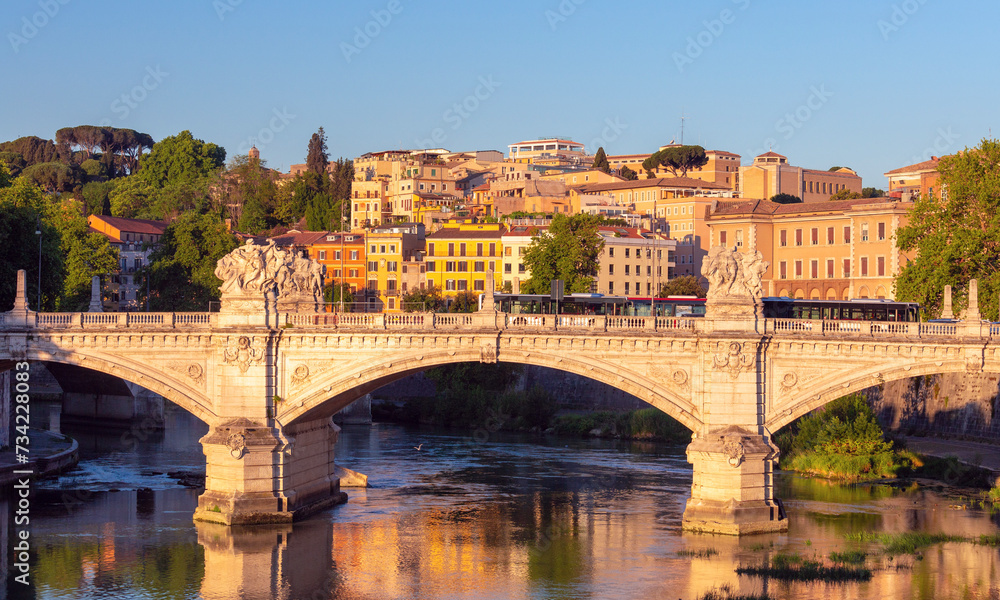 Old stone bridge over the Tiber river in Rome early in the morning.