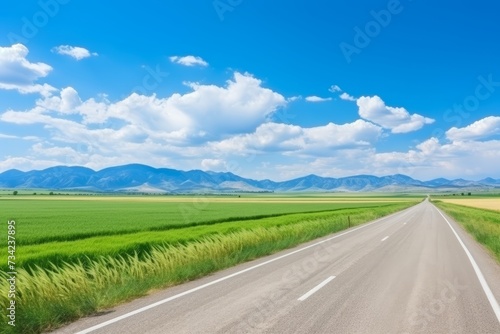 A serene motorway surrounded by majestic mountains in the vibrant glow of a sunny day