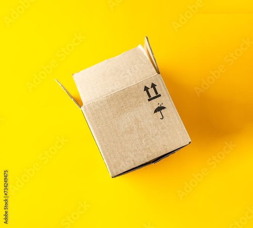 open cardboard box on yellow background, close-up photo