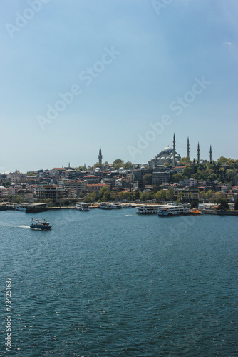 view of district galata tower in bosphorus strait magnific city istanbul with boats passing by and huge mosquee on top of hill