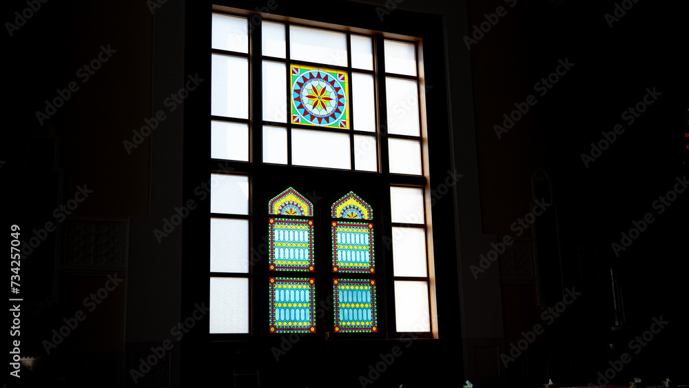 Sun light coming through the colorful stained glass window of a mosque.