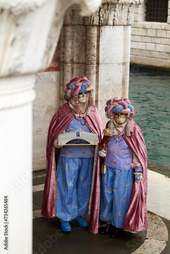 Venice, Italy - February 2022 - carnival masks are photographed with tourists in San Marco square