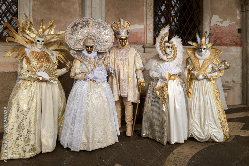 Venice, Italy - February 2022 - carnival masks are photographed with tourists in San Marco square Venice, Italy - February 2022 - carnival masks are photographed with tourists in San Marco square