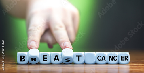 Hand turns dice and changes the expression 'breast cancer' to 'beat cancer'.