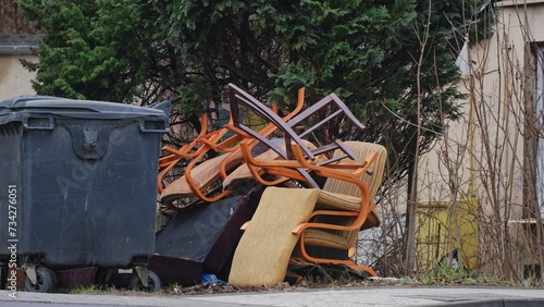 Old Furniture Stacked By Dumpster for Curbside Garbage Collection by City Cleaning Service photo