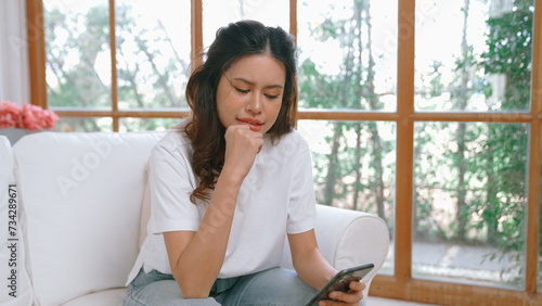 Young woman using smartphone browsing for online shopping E commerce by online payment gateway at vivancy home. Modern and convenience online purchasing make secure and convenient purchases.