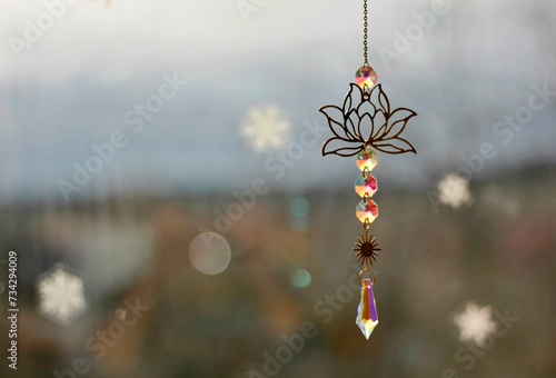 Glass hanging window decoration with glued snowflakes and blurred background