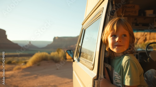 Child looks out of the window of campvan on the road