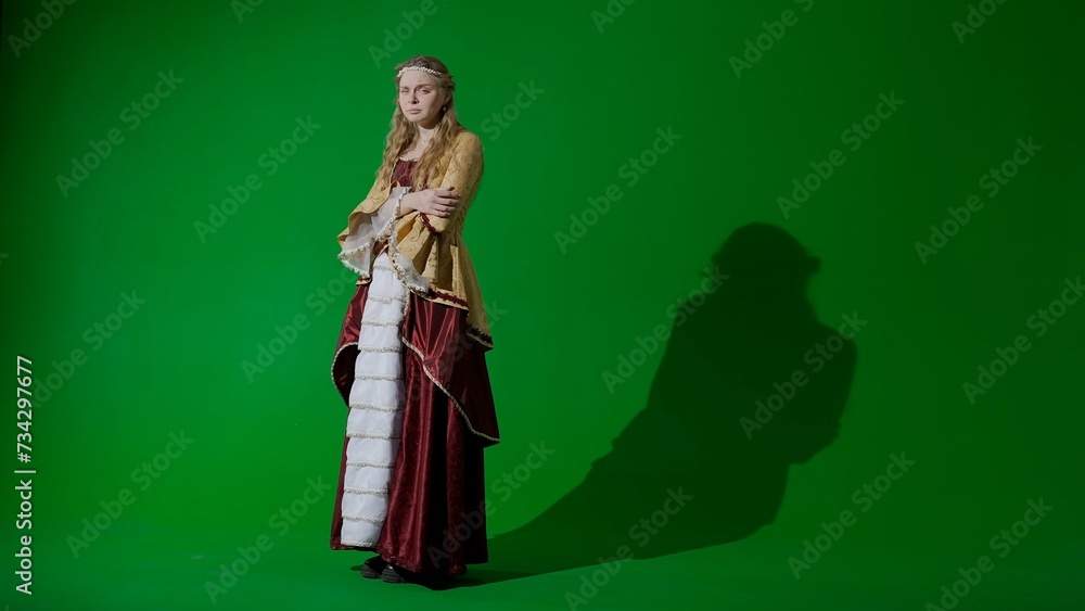 Woman in ancient outfit on the chroma key green screen background. Female in renaissance style dress posing looking at the camera, crying sad face. Woman in ancient outfit on the chroma key green screen background. Female in renaissance style dress posing looking at the camera, crying sad face.
