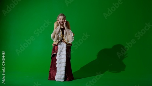 Woman in ancient outfit on the chroma key green screen background. Female in renaissance style dress looking at the camera  amazed surprised face.