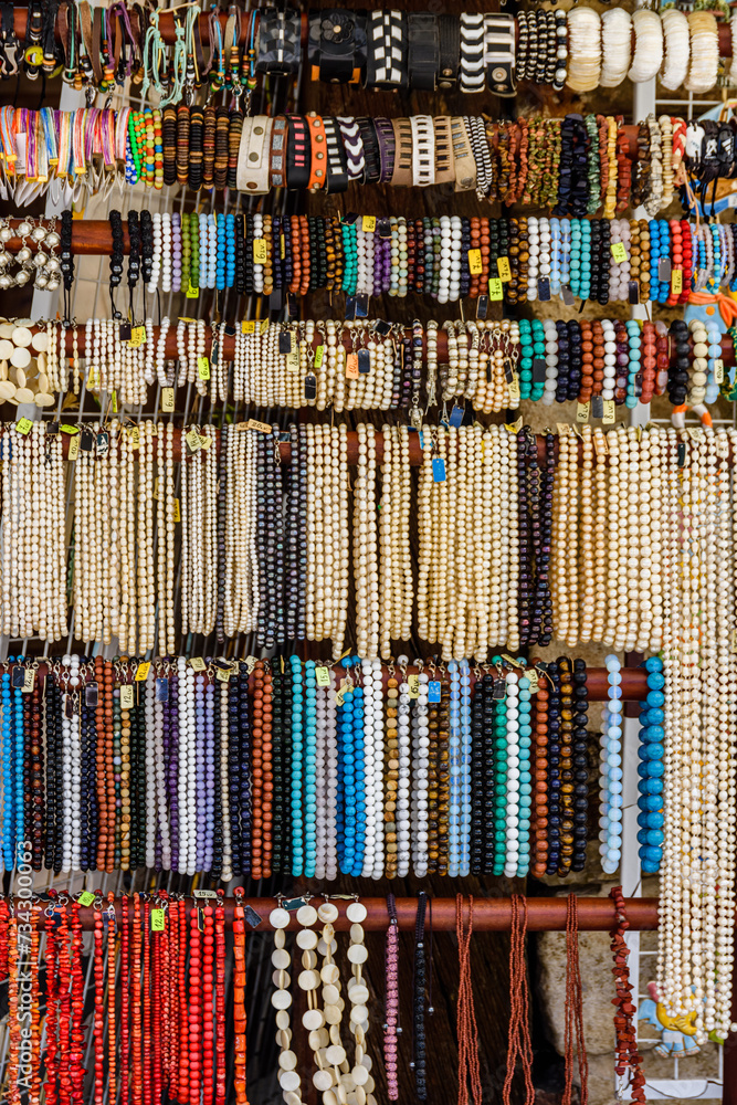 Different wristbands and necklaces for sale on a street fair