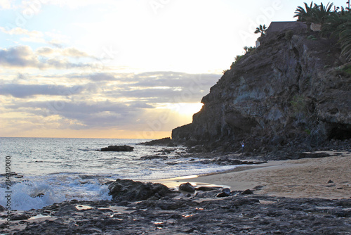 Sonnenuntergang am felsigen Strand mit Palmen in Morro Jable auf Fuerteventura