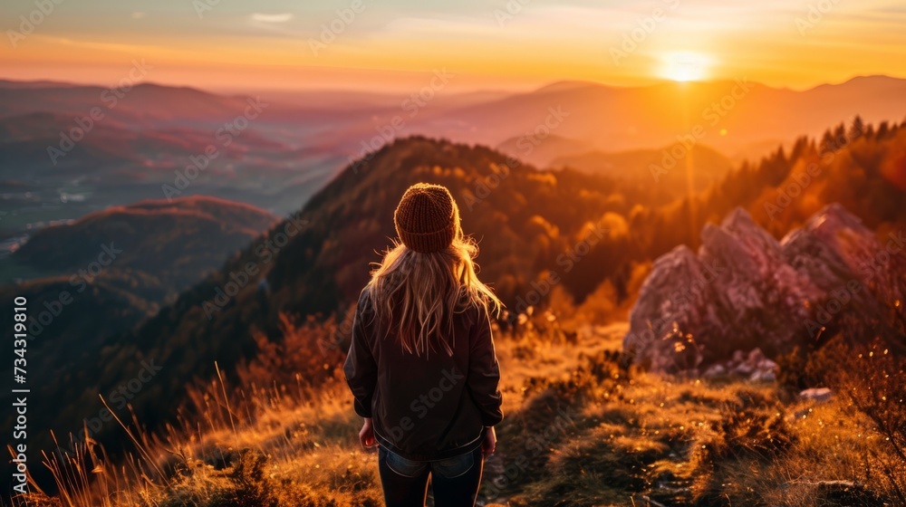 woman from behind, on the top of a mountain, enjoying a sunset generative ai