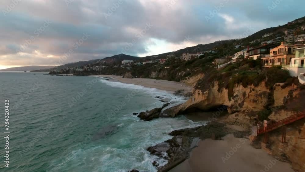 Aerial: Drone Backward Beautiful View Of Houses In Cliff At Beach By Wavy Sea Under Cloudy Sky - Newport Beach, California Aerial: Drone Backward Beautiful View Of Houses In Cliff At Beach By Wavy Sea Under Cloudy Sky - Newport Beach, California