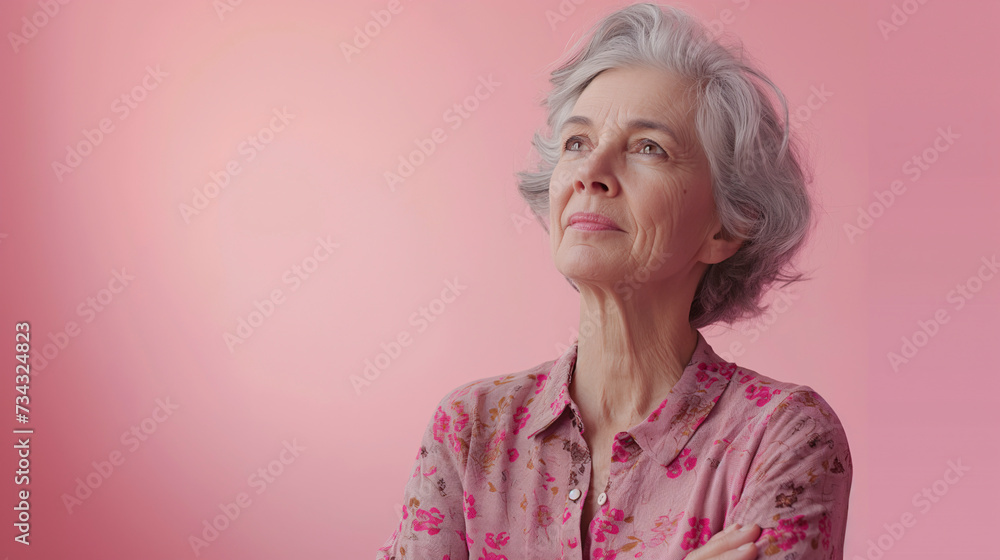 Retrato de mujer madura vestida de color rosa sobre fondo liso de color rosa.  - obrazy, fototapety, plakaty 