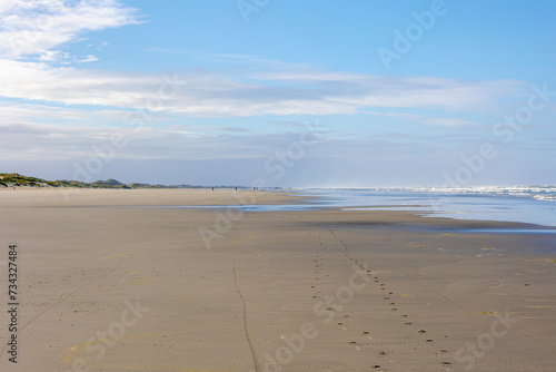 Landscape view of wide and long beach  White sand under blue sky and white puffy could  The Dutch Wadden Sea island Terschelling  A municipality and an island in the northern  Friesland  Netherlands.