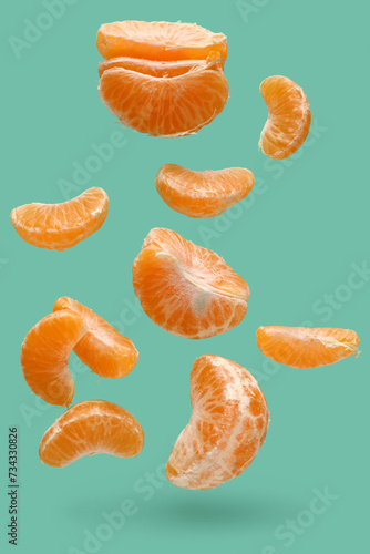 Peeled flying tangerines on turquoise background