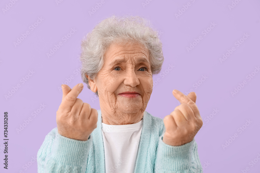 Senior woman making heart with her fingers on lilac background, closeup Senior woman making heart with her fingers on lilac background, closeup