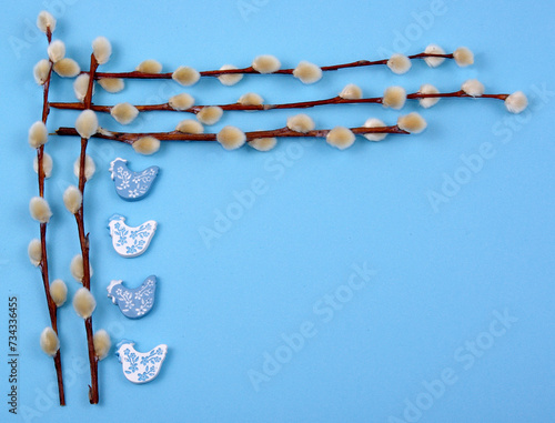 Easter decoration with pussywillow twigs and wooden cocks on blue background for greeting card or poster © Agata