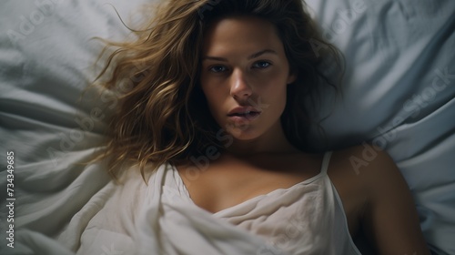 woman lying in bed stock video, in the style of minimalistic portraits, light brown and blue, celebrity photography, strong facial expression