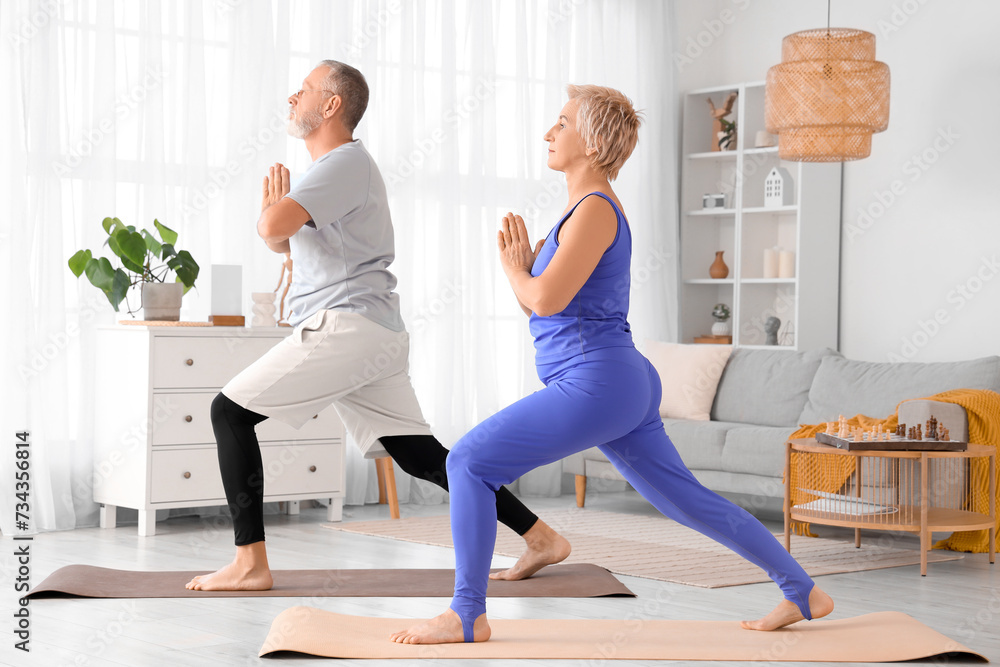 Sporty mature couple doing yoga at home Sporty mature couple doing yoga at home