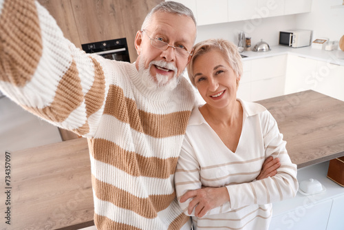 Mature couple taking selfie in kitchen © Pixel-Shot