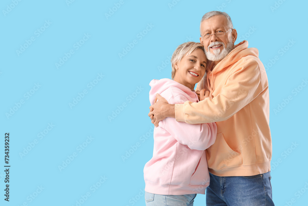Mature couple hugging on blue background Mature couple hugging on blue background