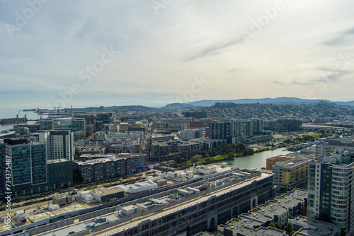 aerial shot of office buildings, apartments and retail stores in the city skyline with ocean water and lush green trees and grass in San Francisco California USA