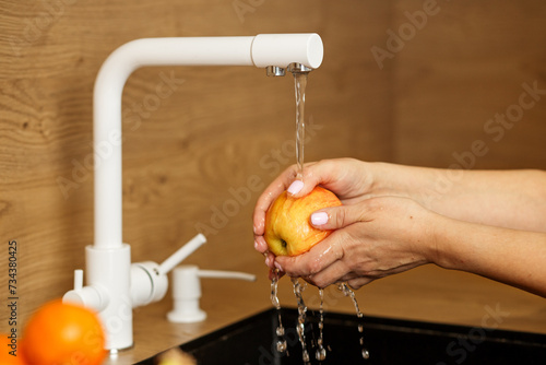 Slika na platnu Washing an Apple Under Tap Water