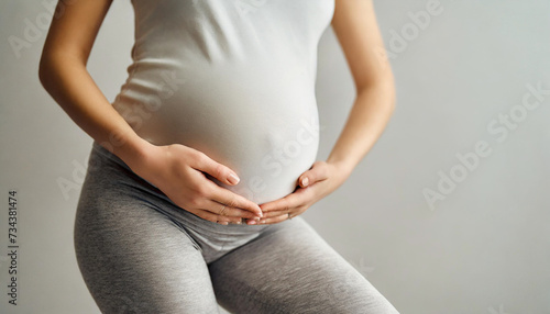 pregnant woman's belly and genital area in light grey tights, symbolizing fertility, hope, and impending motherhood