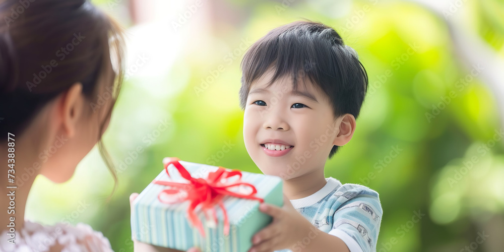 Boy offering a gift to his mother, celebrating mother's day Boy offering a gift to his mother, celebrating mother's day