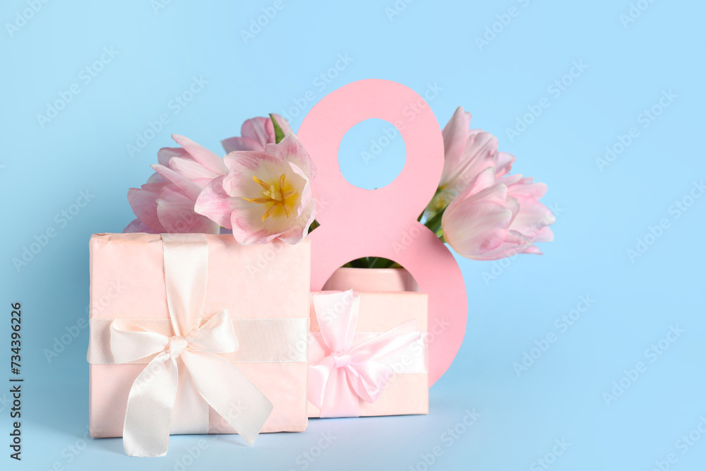 Figure 8 made of paper with gift boxes and beautiful pink tulips on blue background. International Women's Day Figure 8 made of paper with gift boxes and beautiful pink tulips on blue background. International Women's Day