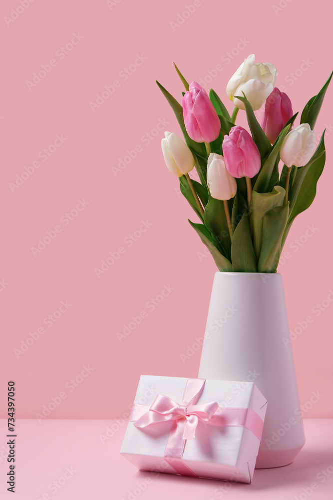 Obraz premium Vase with beautiful tulips and gift box on pink background. International Women's Day