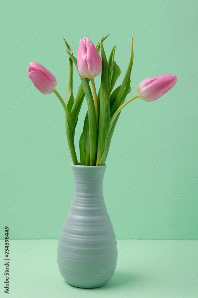 Vase with beautiful pink tulips on green background. International Women's Day
