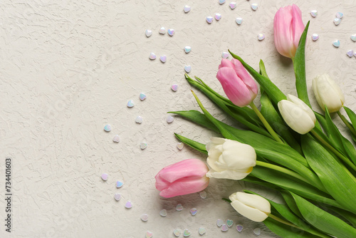 Beautiful tulip flowers with hearts on beige background. International Women's Day celebration