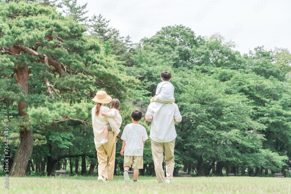 Φωτογραφία 夏休みに公園を手を繋いで歩く家族・ファミリーの後ろ姿（レジャー・アウトドア・ピクニック・キャンプ）