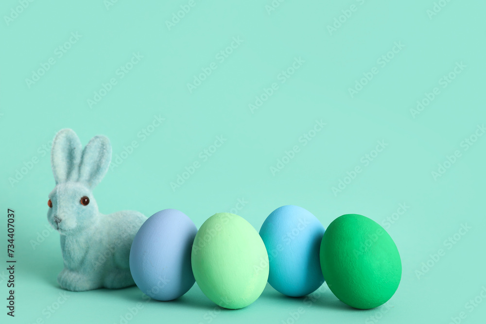 Painted Easter eggs and bunny on turquoise background