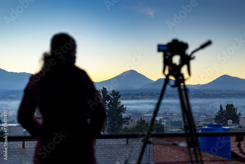 Fotografa esperando, contemplando el solsticio de invierno con los volcanes mexicanos en el amanecer del invierno de diciembre. Iztaccihuatl y Popocatepetl. México.