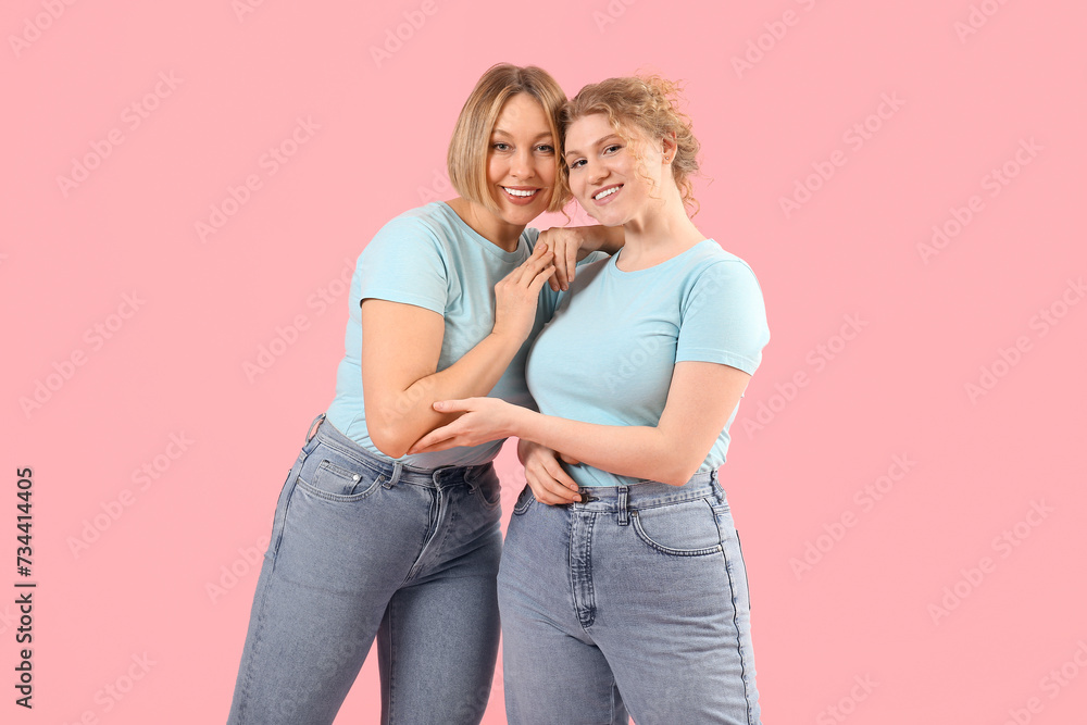 Beautiful happy women in stylish jeans on pink background Beautiful happy women in stylish jeans on pink background