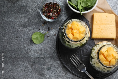 Healthy salad in glass jars on grey table, flat lay